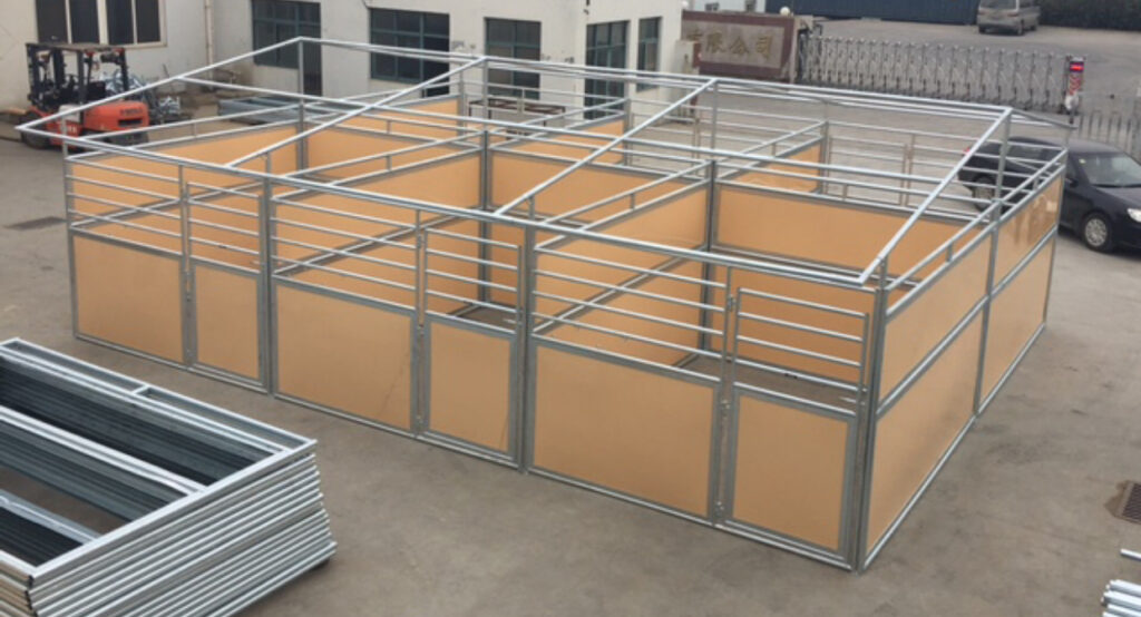 Galvanized portable horse stalls with poly panels set up indoors